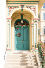 Fototapeta na wymiar Pretty turquoise colored door with holiday decor