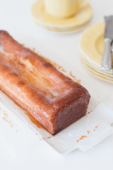 Freshly baked and homemade lemon pound cake or Madeira cake with lemon sugar icing on white table