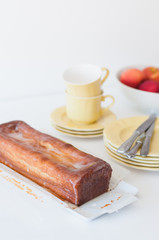 Freshly baked and homemade lemon pound cake or Madeira cake with lemon sugar icing on white table