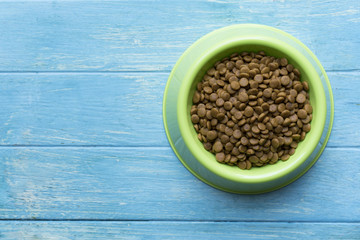 Dog food in a bowl on table background