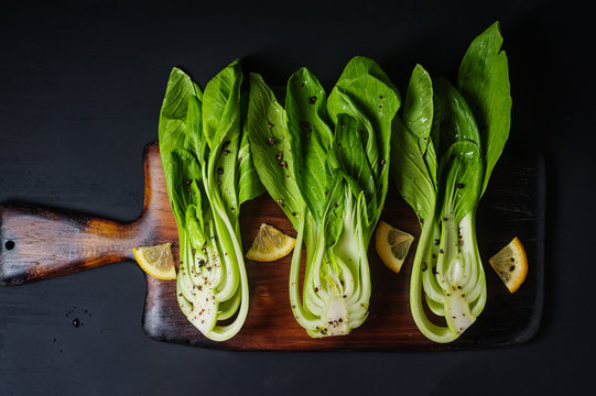 Fresh Chinese cabbage or Bok Choy with lemon slice and pepper on blue dish
