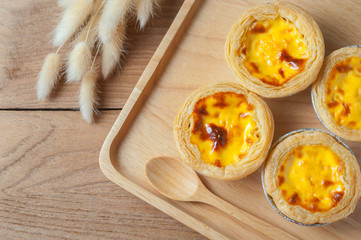 Delicious Egg tart, traditional Portuguese dessert, on wooden plate for coffee break on rustic...