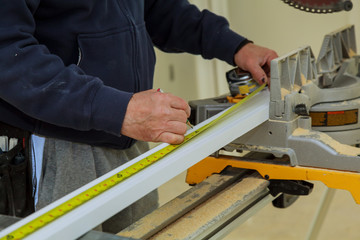 Close-up The man measures a wooden board with a ruler and marks with pencil