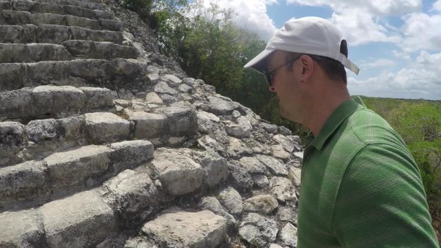 Man climbs big stairs at Ek Balam Mayan ruins in Mexico