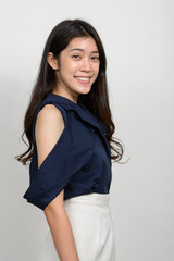 Portrait of young beautiful Asian woman against white background
