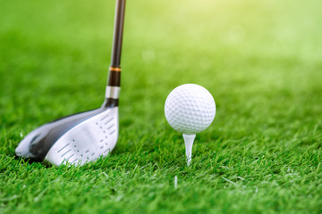 Golf club and ball on green grass