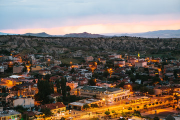 Fototapeta na wymiar Top view. A small authentic city called Goreme in Cappadocia in Turkey in the evening. Dramatic night sky, sunset.