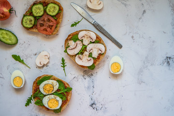 Ciabatta for breakfast. Sandwiches with arugula, egg, mushrooms, cucumbers and tomatoes