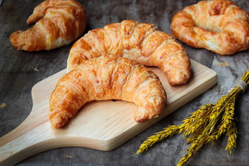 freshly baked croissants on wooden cutting board, top view