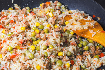 Minced meat with rice and vegetables in a frying pan. Close up