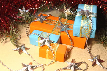 Gifts for the holiday Christmas and New Year in orange and blue boxes lie under a Christmas tree...