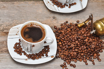 Coffee cup and coffee beans with rustic coffee grinder. 
