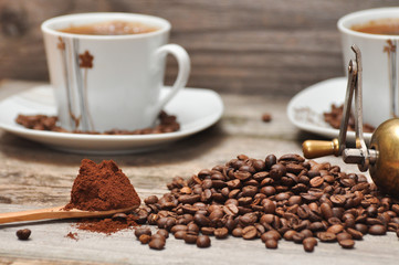 Coffee cup and coffee beans with rustic coffee grinder. 
