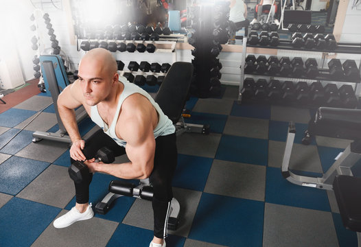 Strong athletic men pumping up muscles and train in gym workout
