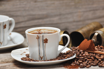 Coffee cup and coffee beans with rustic coffee grinder. 
