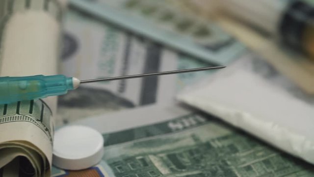 Pills, drugs, cocaine, syringe on dollar bank notes.