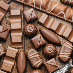 Background of chocolates, bars and sweets, free space for text, close up