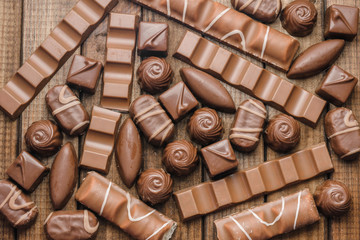 Background of chocolates, bars and sweets, free space for text, close up