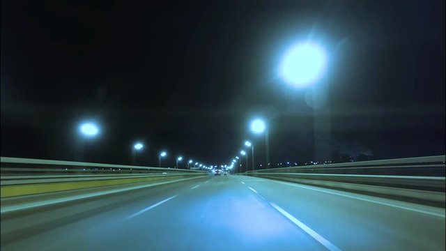 Time lapse of driving a car in the city at night time. POV. Hyper laps in the evening downtown.