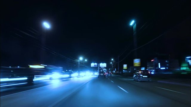 Time lapse of driving a car in the city at night time. POV. Hyper laps in the evening downtown.