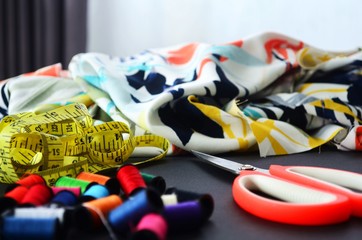 Fototapeta premium Stoffe, Maßband, Schere und Garn zum nähen