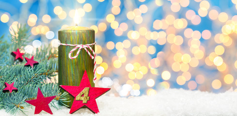 Vierter Advent, Adventsdekoration, Kerze und Sterne im Schnee vor Bokeh