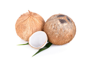 whole mature and half cut young coconut with leaf on white background