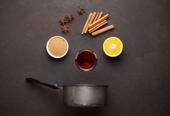 Ingredients for cooking mulled wine on brown stone background.