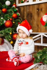 Happy santa baby girl play mobile phone