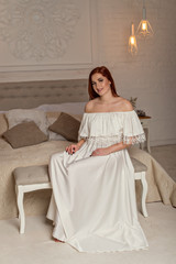 Fototapeta premium Portrait of luxury happy young girl and evening makeup, wears evening white dress. Vogue style model girl in elegant long dress.