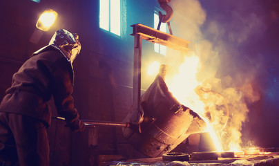 Worker controlling metal melting in furnaces. Workers operates at the metallurgical plant. The...