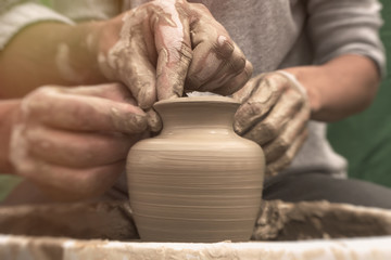 Potter's hands. Potter teaches the student the art of clay pottery
