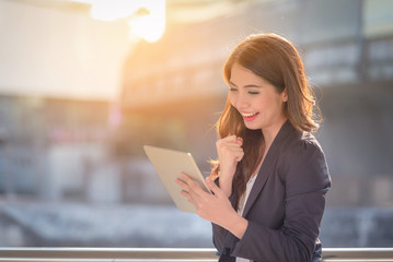 Portrait of business woman happy smile looking digital tablet on blurred background. Business...