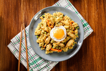 Fried rice nasi goreng with chicken egg and vegetables on a plat