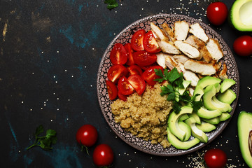 Healthy food, avocado, quinoa, chicken and tomatoes on plate, top view