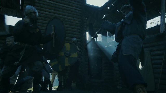 Medieval Battle Reenactment. Viking and Slav Warriors Fight With Swords, Axes and Shields in the Yard of the Wooden Fortress. Shot on RED EPIC-W 8K Helium Cinema Camera.