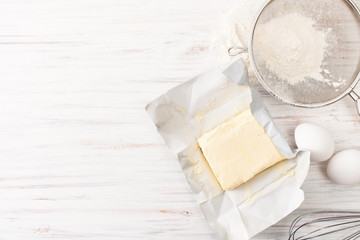 Eggs, flour, butter on a white table. Place for text.
