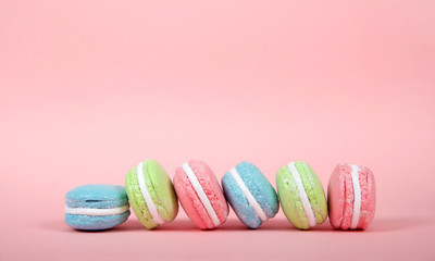 Large Macaroon cookies covered in granulated sugar on a table. pink background. Popular pastry in France.