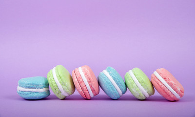 Large Macaroon cookies covered in granulated sugar on a table. Purple background. Popular pastry in France.