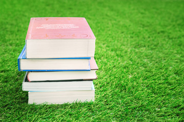 Stack of books on green grass