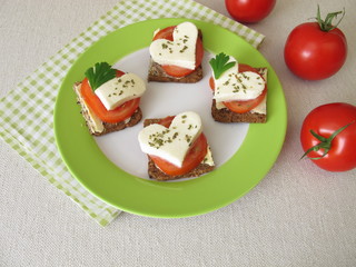 Leinsamenbrot mit Tomate, Mozzarellaherz und Sellerieblättern