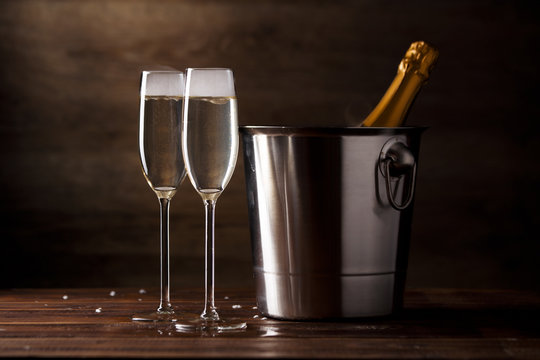 Festive photo of two wine glasses with sparkling wine, iron bucket