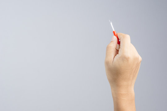 Hand holding seam ripper or thread picker
