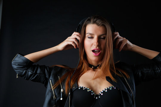 Picture of beautiful girl in headphones on black background