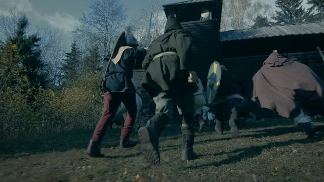 Medieval Battle Reenactment. Violent Tribe of Warriors Attacks Wooden Fortress, They Run Through the Gates.  Shot on RED EPIC-W 8K Helium Cinema Camera.