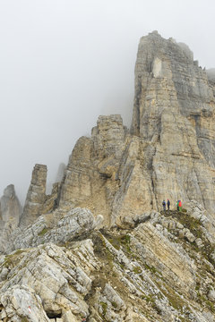 Persons hiking on rock ridge to Torre di Pisa, Latemar range, Dolomites, UNESCO world heritage Dolomites, Trentino, Italy