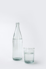 bottle and glass with mineral water isolated on white