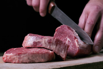 Butcher cutting beaf meat on kitchen. Food background