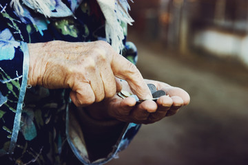 Grandmother counts coins in her wrinkled hands close up