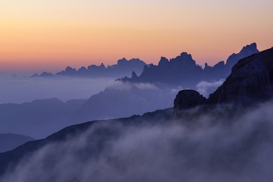 Fog covering Tre Cime di Lavaredo at sunrise, Veneto, Italy